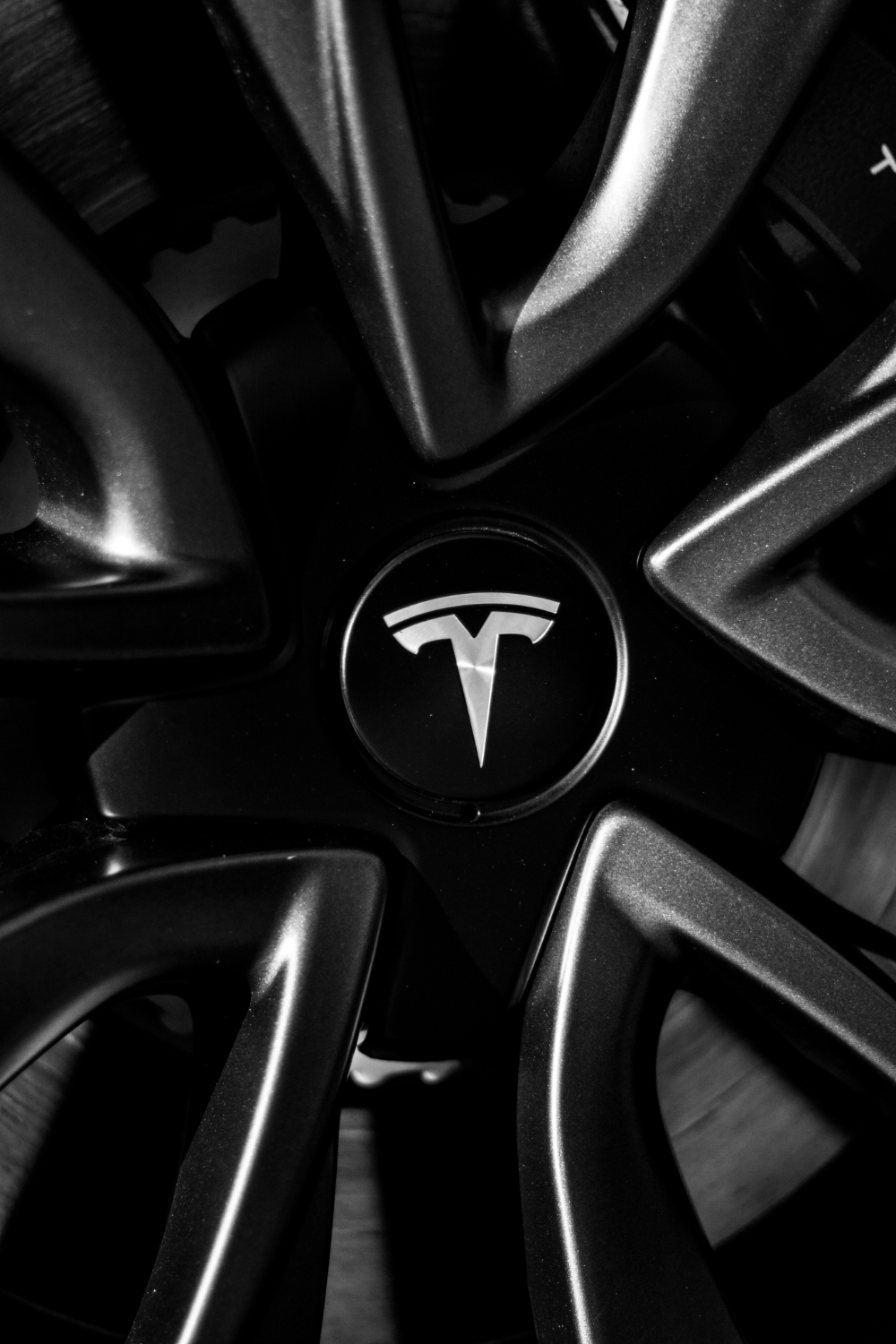 Nahaufnahme eines schwarzen Tesla-Felgenmittelteils mit weißem Tesla-Logo